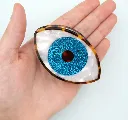 Pince Œil bleu pailleté Coucou Suzette en acétate présentée dans la main.webp