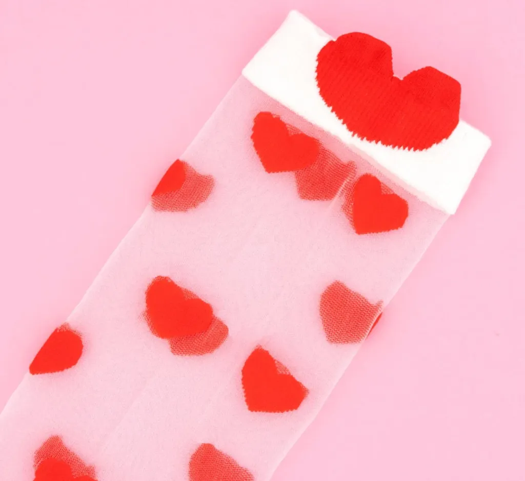 Détail chaussettes transparentes Coucou Suzette à motifs cœurs rouges et bord blanc.webp