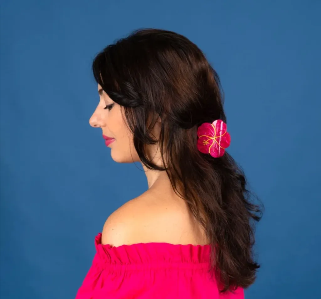 Pince à cheveux hibiscus rose portée dans les cheveux.webp