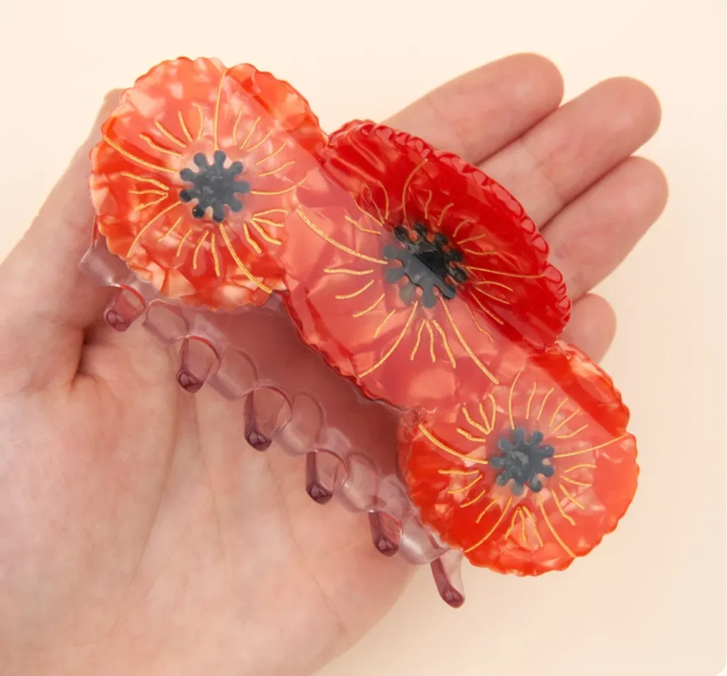 Grande pince à cheveux Coquelicots Coucou Suzette présentée dans la main.webp