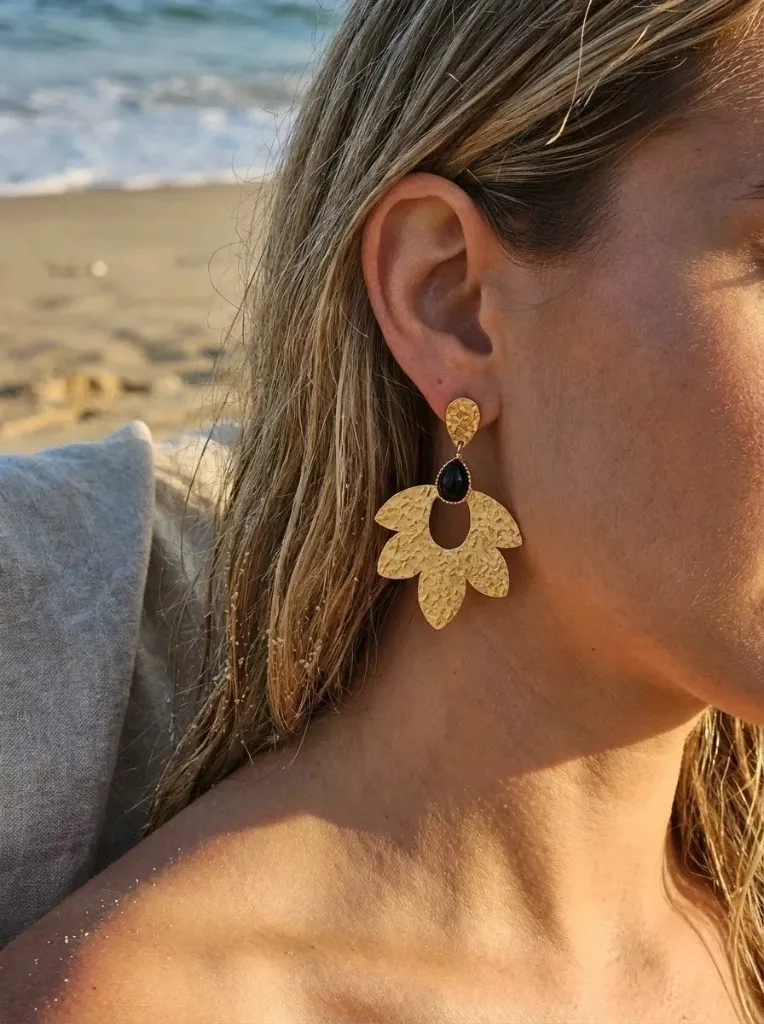 Boucles d’oreilles pendantes dorées fleur texturée avec pierre noire portées | Le Moulin à Paillettes.webp