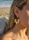 Boucles d’oreilles pendantes dorées fleur texturée avec pierre noire portées | Le Moulin à Paillettes.webp